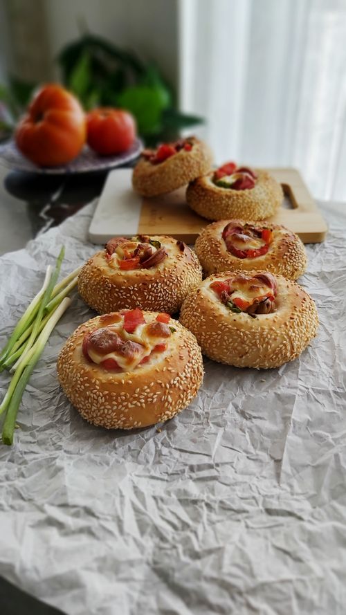 Free A close-up of freshly baked bagels with assorted toppings on a rustic surface. Stock Photo