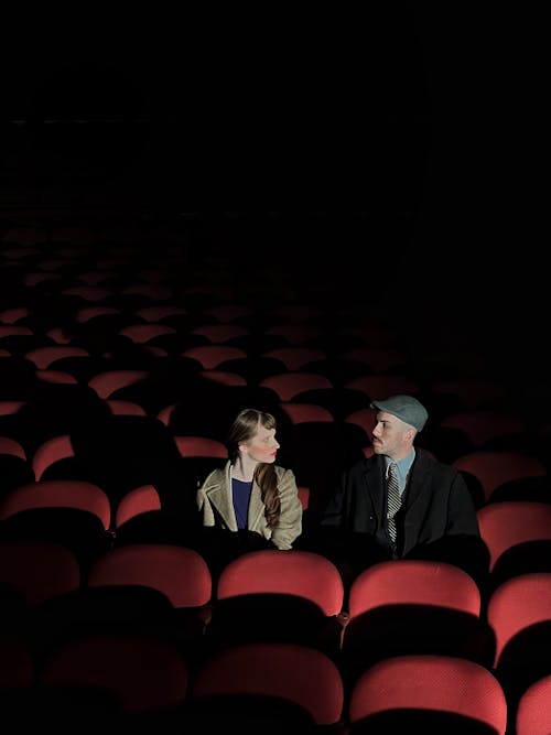 Man and Woman Sitting in a Cinema Alone 