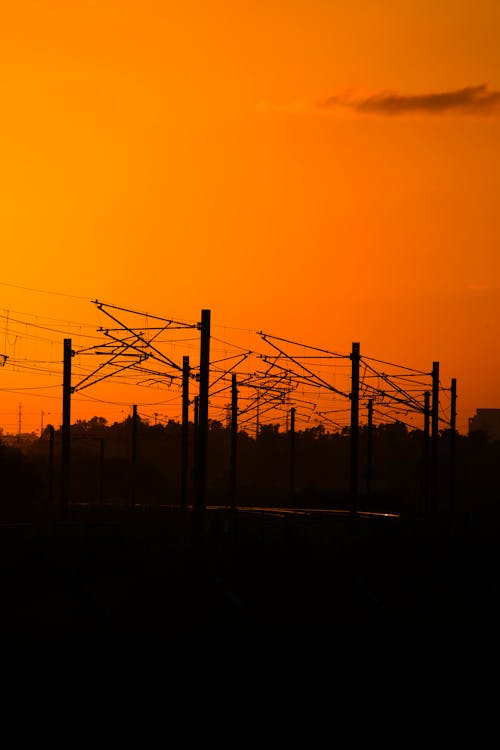 Immagine gratuita di cielo arancione, ora d'oro, pali dell'elettricità