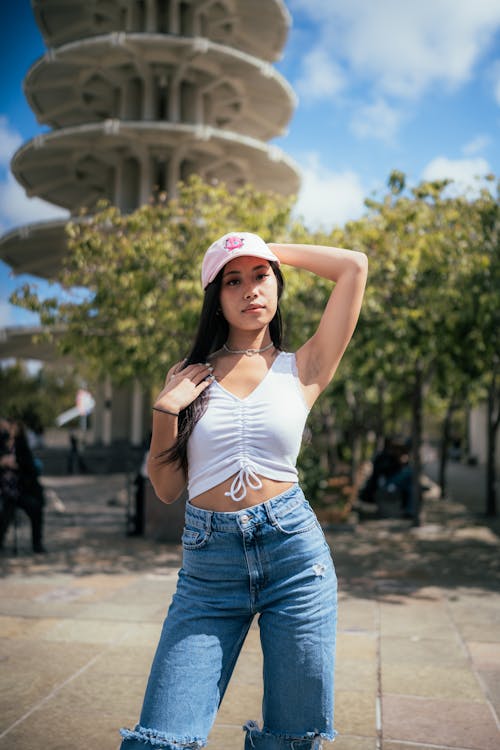 A Woman in White Tank Top and Denim Jeans Posing