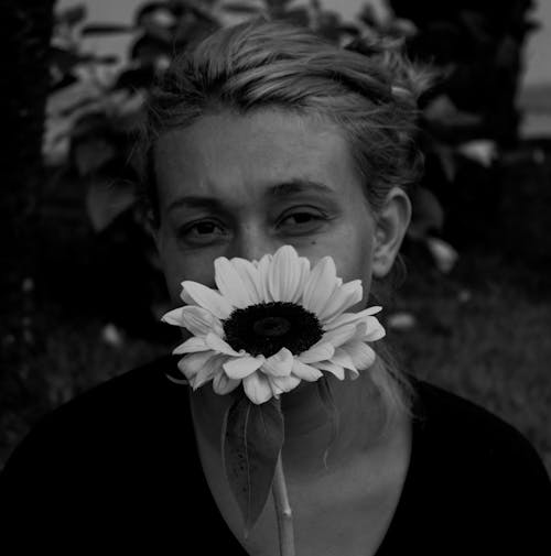A Grayscale Photo of a Woman Holding Flower