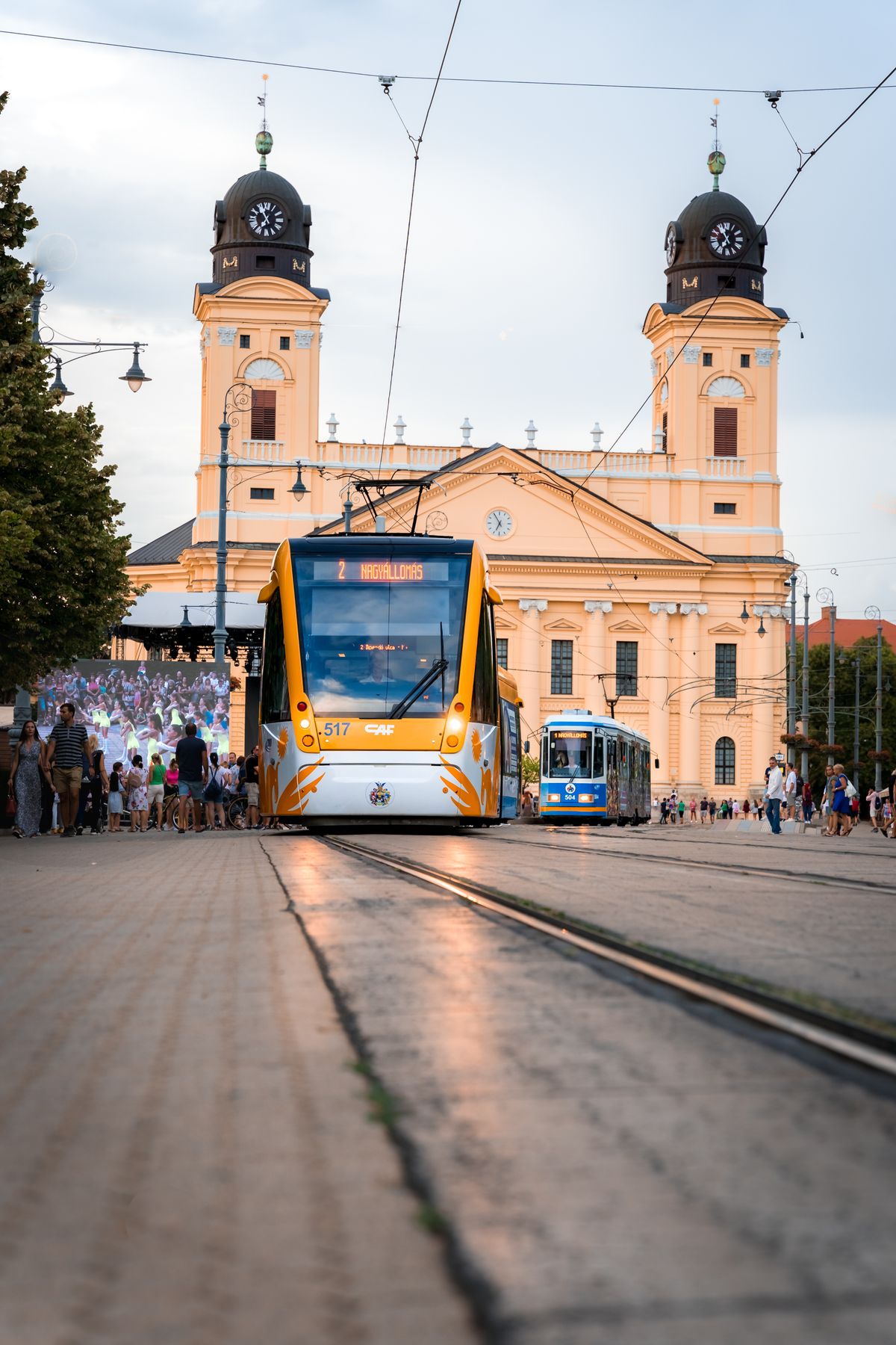 Tram passing the yellow Reformed Great Church in Debrecen