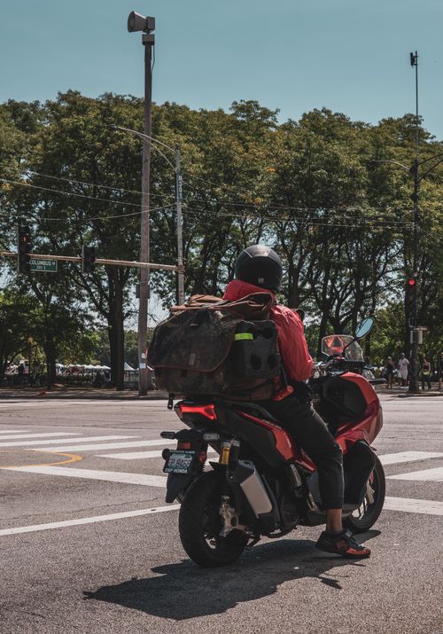 Free A motorcyclist waits at a Chicago intersection under a clear summer sky. Stock Photo