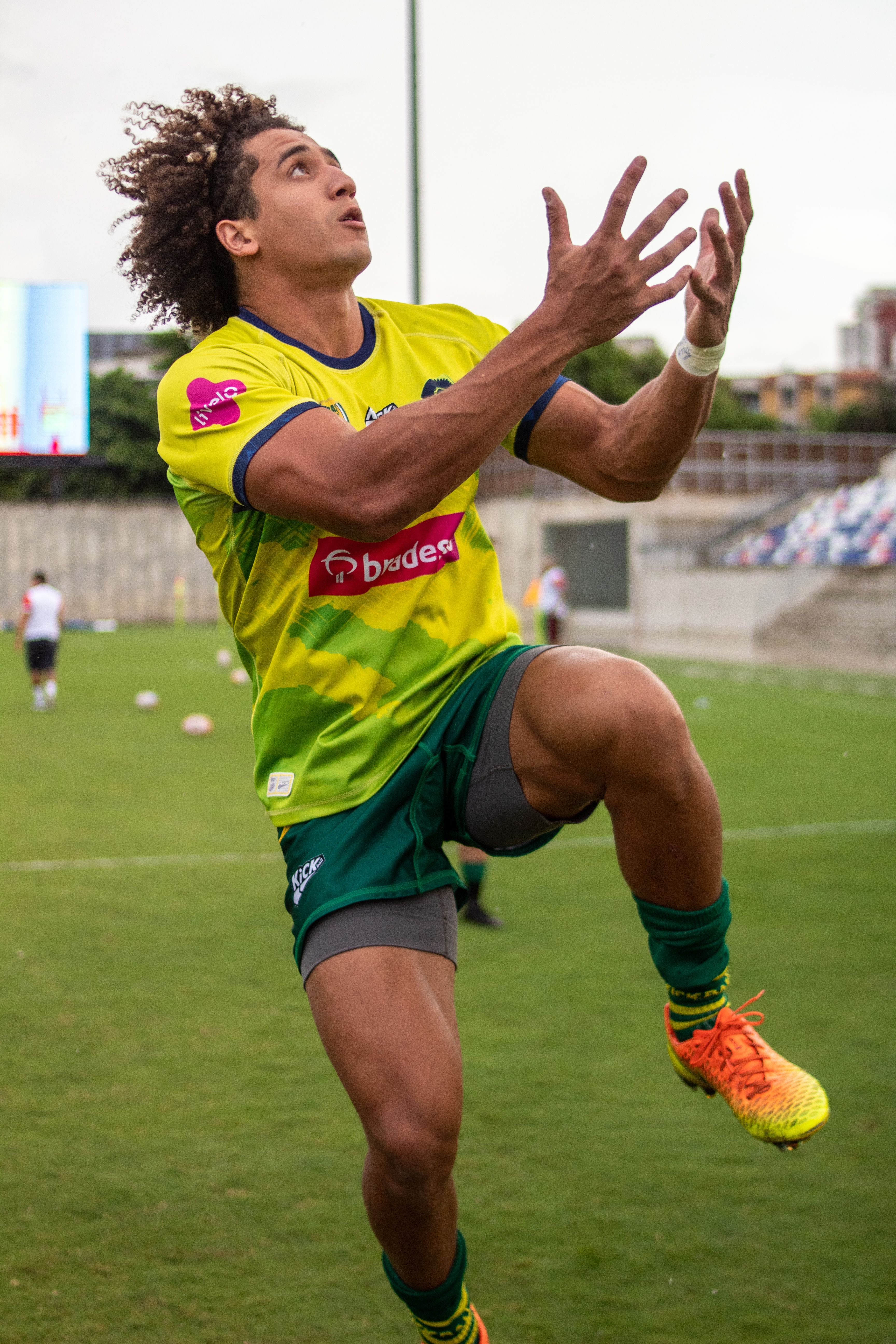 Athlete in action catching a ball during an outdoor sports event.