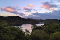 在新西兰五彩缤纷的天空下，湖泊宁静的景色绿树成荫、群山环绕