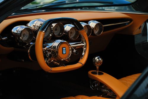 Free Close-up of a luxury sports car interior showcasing a sleek dashboard and steering wheel. Stock Photo
