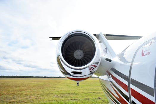 Detailed view of a private jet's engine on a sunny day at a rural airstrip.