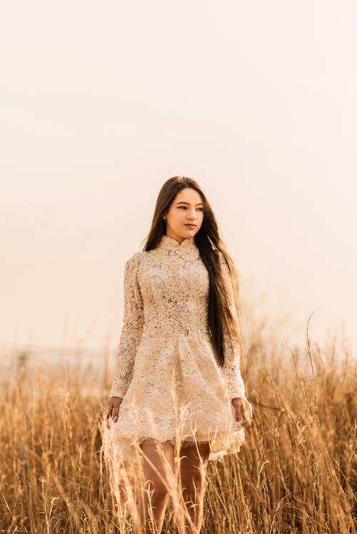 Young Brunette Woman in a Dress Walking Through a Field 