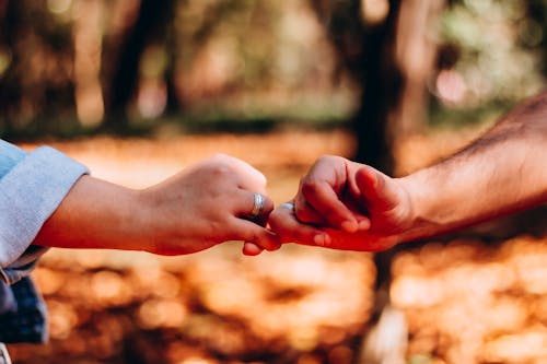 People Holding Hands Wearing Silver Ring