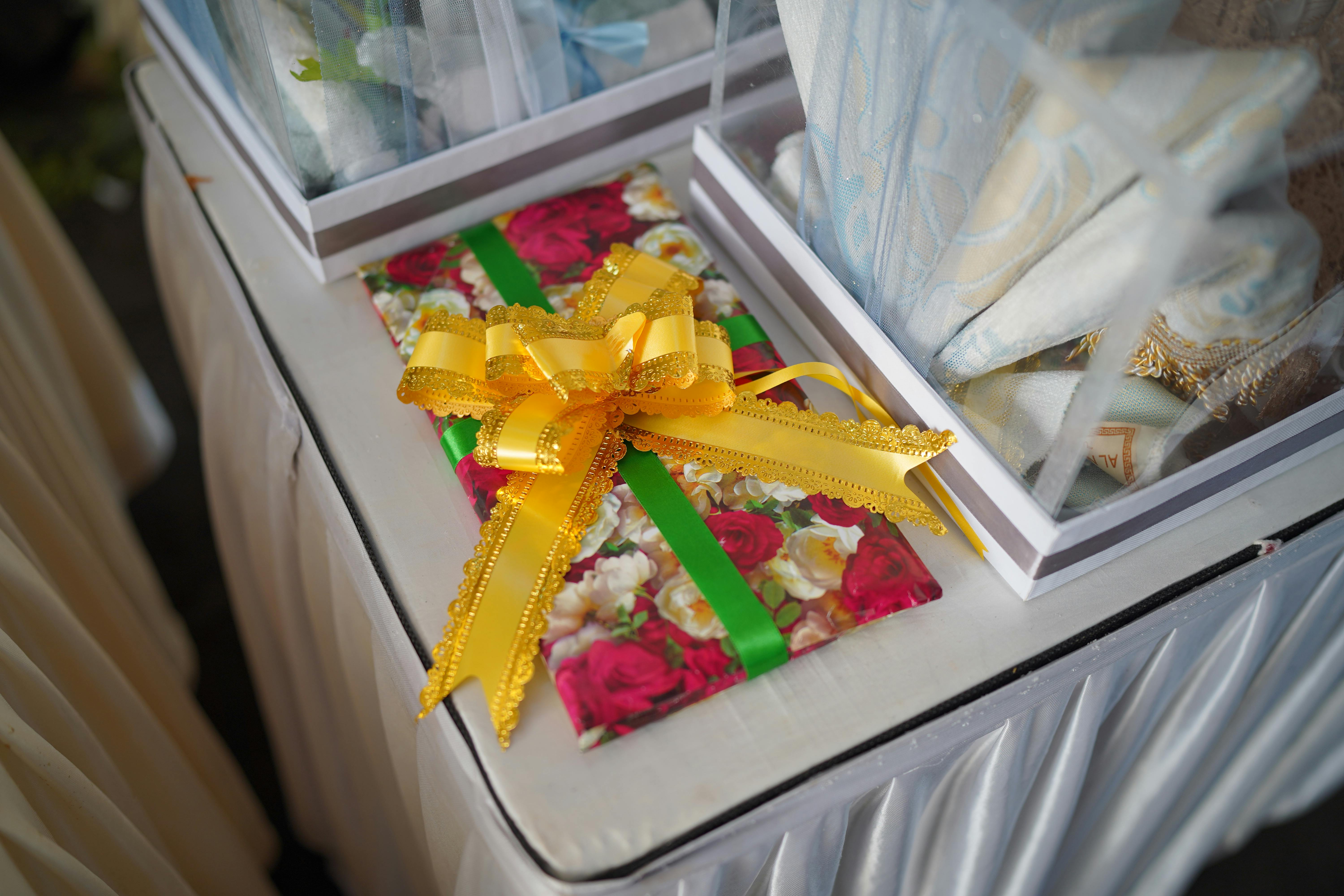 Close-up of a beautifully wrapped gift with a yellow bow on a decorated table setting.