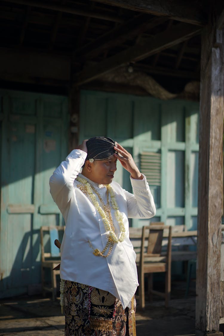 Man Putting On Traditional Hat