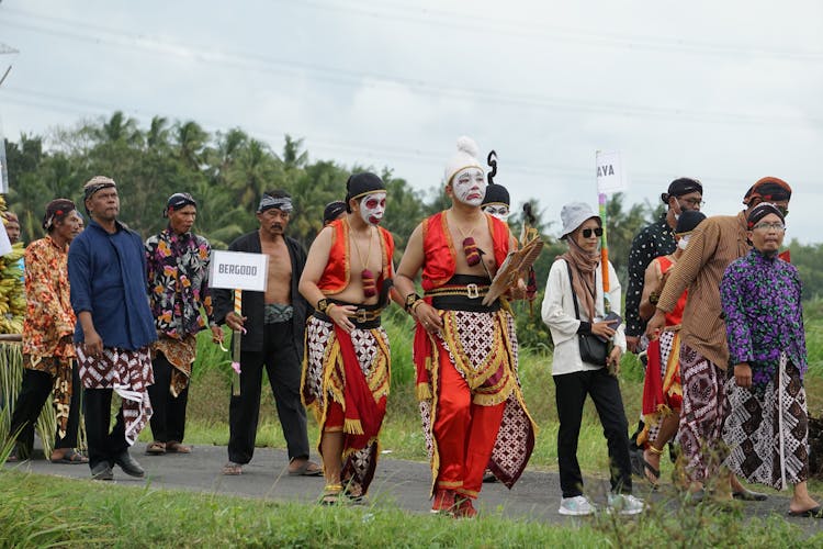 People In Traditional Costumes Walking In Countryside On Ceremony