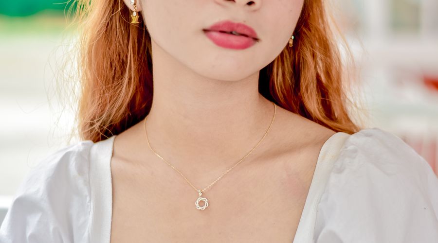 Femme portant un collier doré fin adapté à un décolleté en V