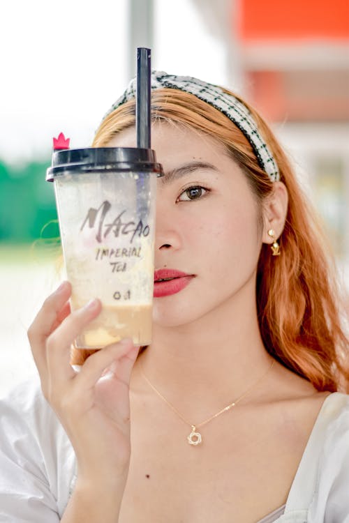 Free A Portrait of a Young Woman Holding Milk Tea in a Disposable Cup Stock Photo