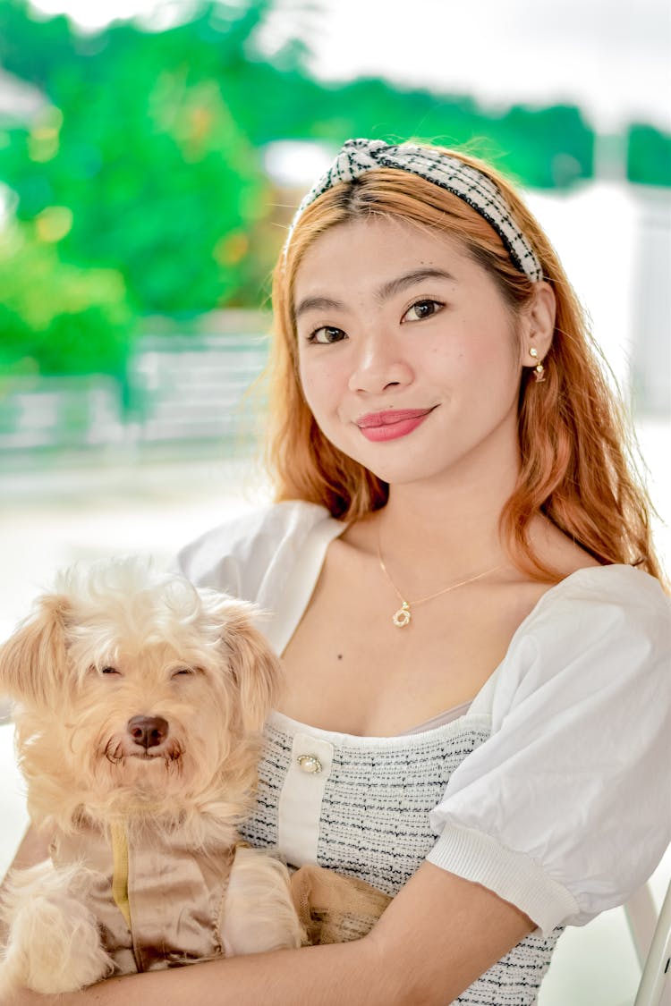 A Portrait Of A Young Woman Holding A Dog