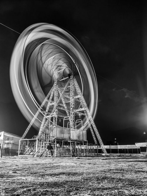 Free Stunning black and white long exposure of a Ferris wheel spinning at night. Stock Photo