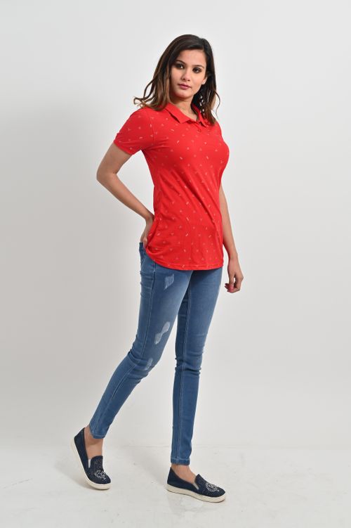Free Woman posing in red polo shirt and denim jeans in a studio with white background. Stock Photo