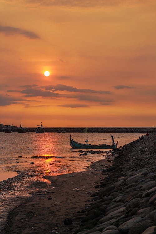 Blue Boat on Body of Water during Sunset