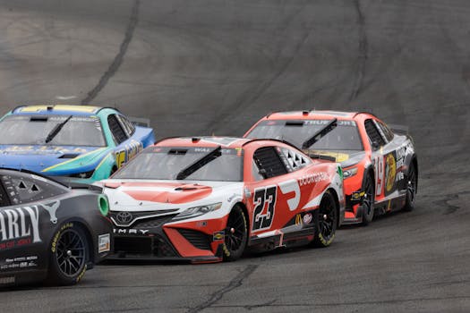 Dynamic image of stock cars racing closely on a track during a motorsport event.