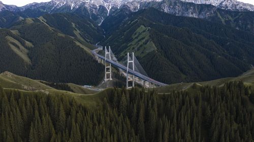 Free A breathtaking aerial view of the Guozigou Bridge set amidst Xinjiang's majestic mountain ranges. Stock Photo