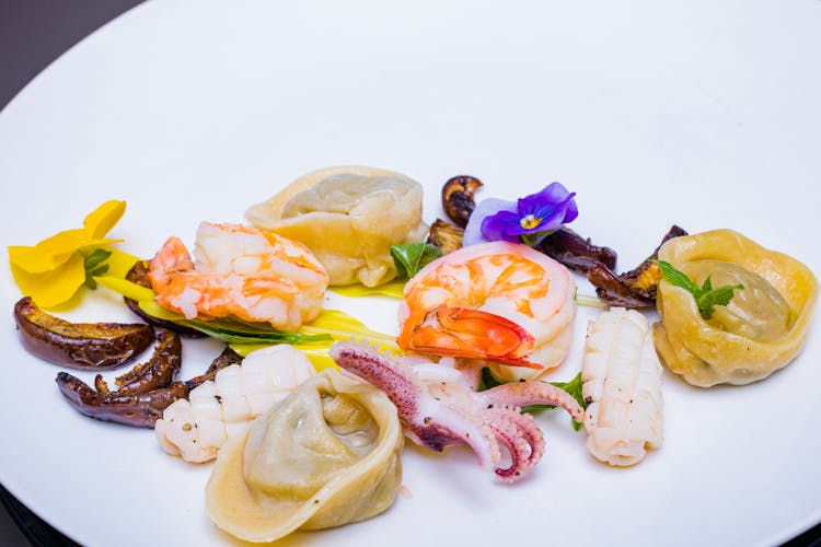 Seafoods On The White Plate With Garnish