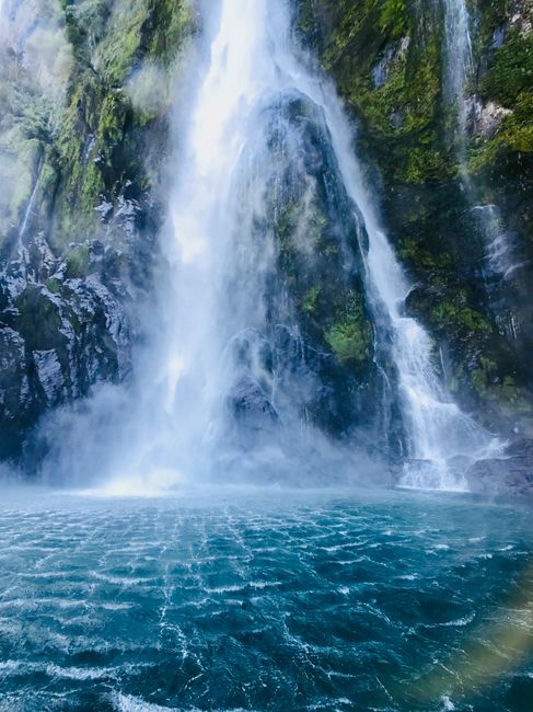 A stunning waterfall cascading into a turquoise pool in Southland, New Zealand.