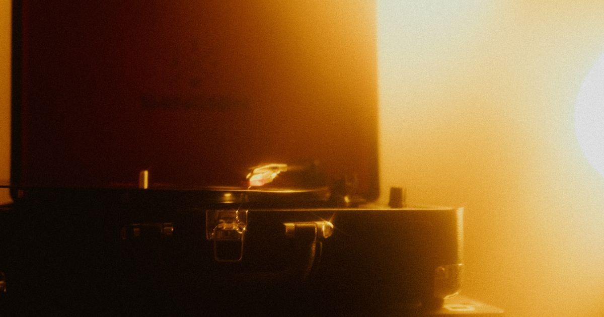Retro turntable playing vinyl in atmospheric warm lighting, evoking nostalgia.
