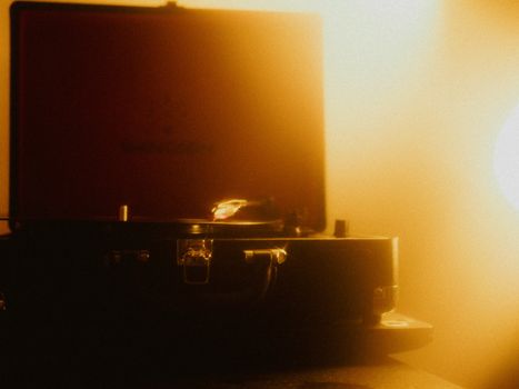 Retro turntable playing vinyl in atmospheric warm lighting, evoking nostalgia.