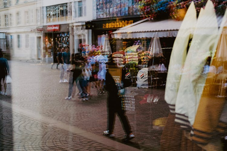 Reflection In Window Of People Walking On Street