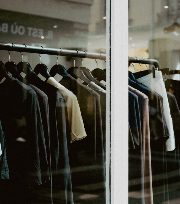Garments on hangers viewed through a fashion store window display