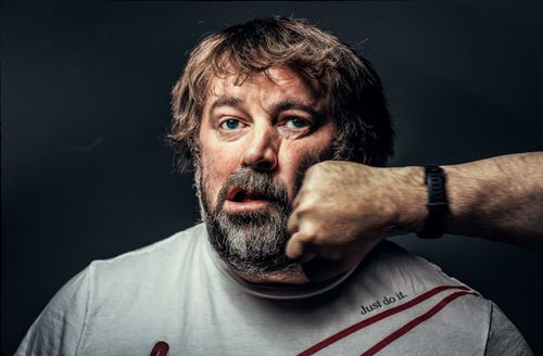 Free A close-up portrait of a bearded man being punched, showcasing a dramatic expression. Stock Photo