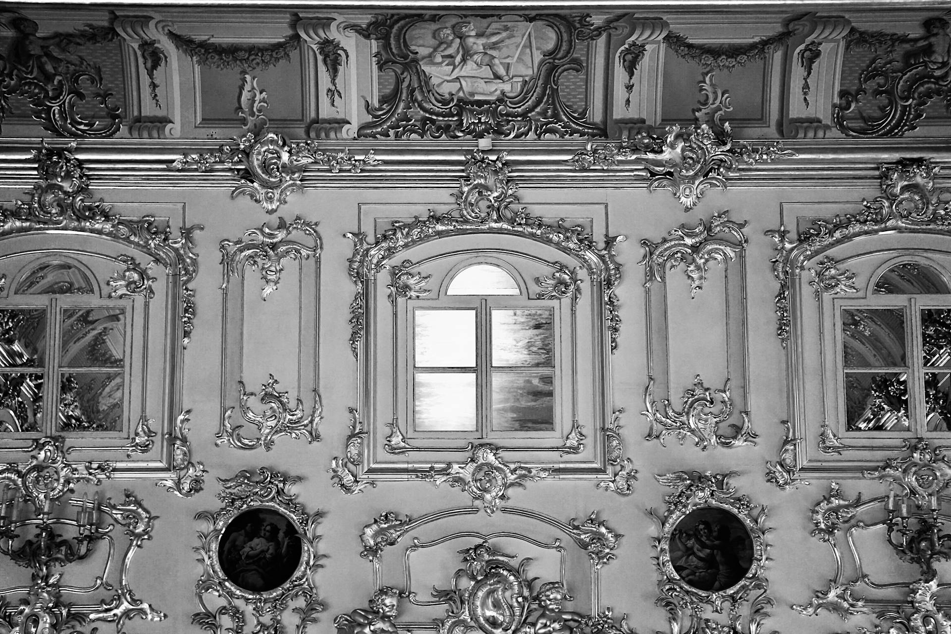 Black and white image of ornate Baroque interior design with decorative windows and frames.