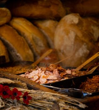 Close-up of sliced meat with rustic bread in a market setting, exuding a warm and earthy mood.