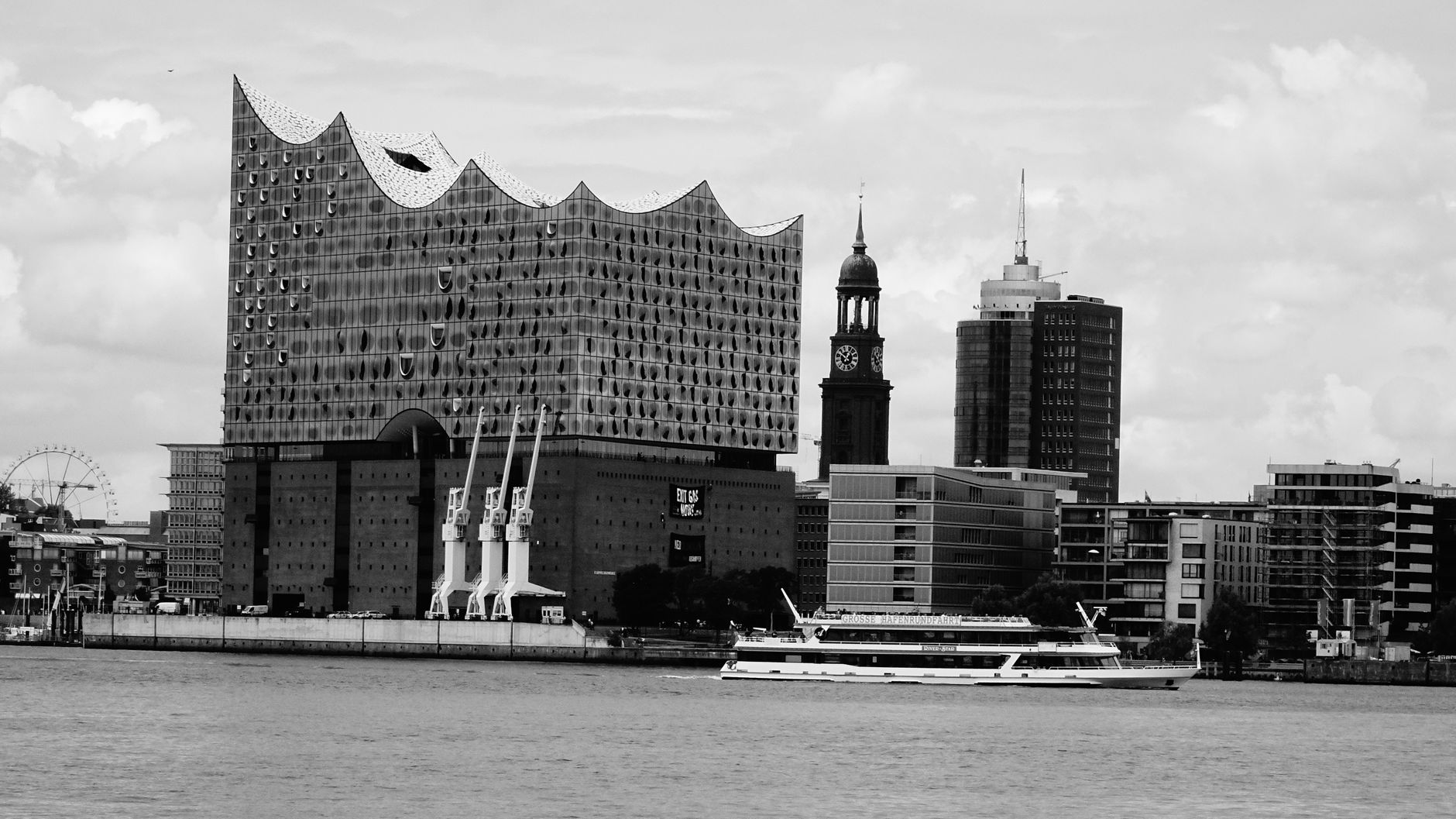 Black and white view of Elbphilharmonie and Hamburg skyline from waterfront.