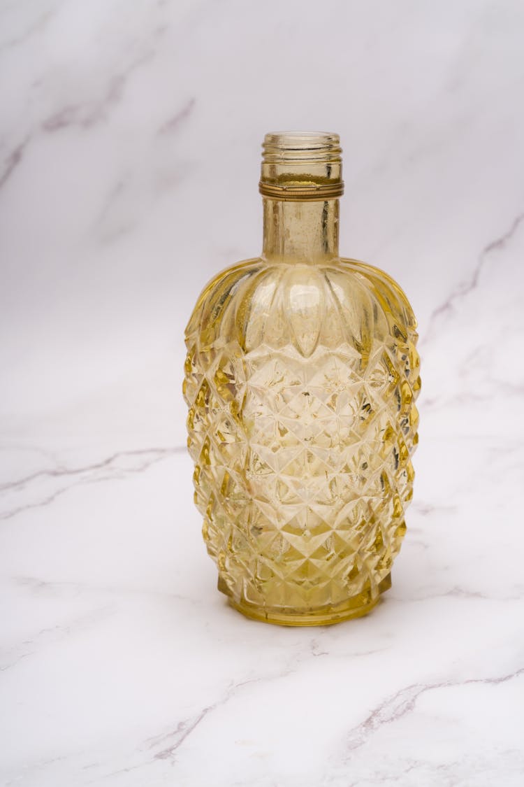 A Yellow Glass Bottle On Marble Surface 