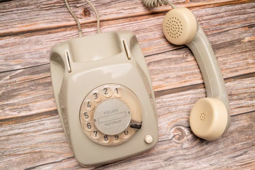 Classic rotary dial telephone on rustic wooden background, evokes nostalgia and retro style.