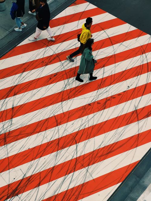 Free High angle view of people walking on a vibrant zebra crossing in an urban setting. Stock Photo
