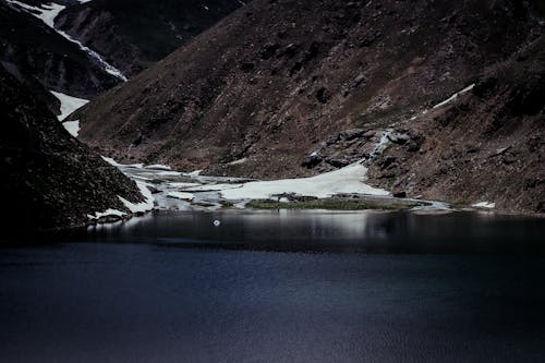 Stream in Snow between Hills over Lake