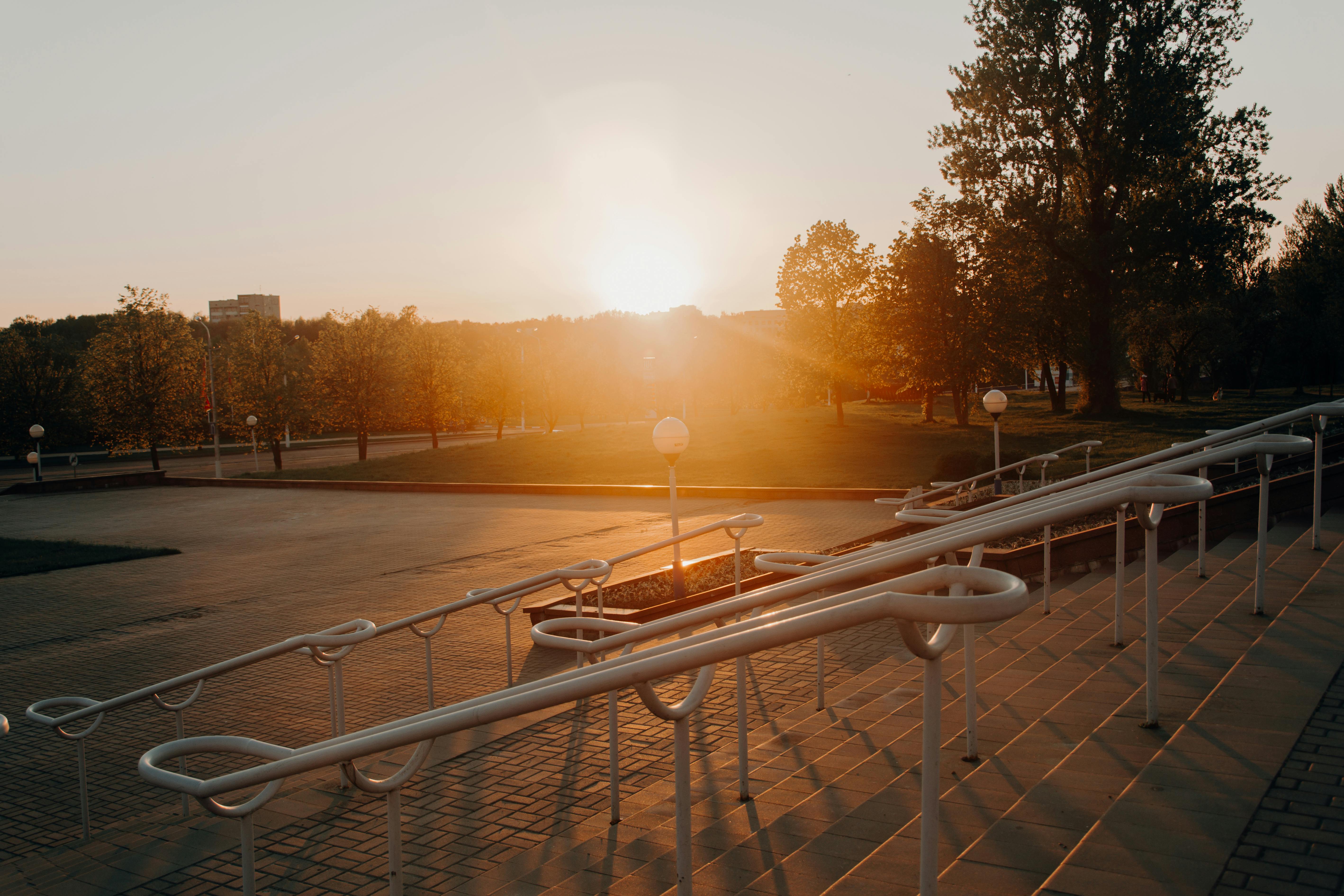 公园里，现代楼梯扶手旁，一个宁静的日落沐浴在温暖的阳光中