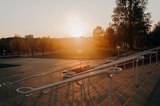 公园里，现代楼梯扶手旁，一个宁静的日落沐浴在温暖的阳光中