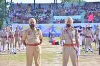 Uniformed officers stand in formation during a traditional military parade with spectators.