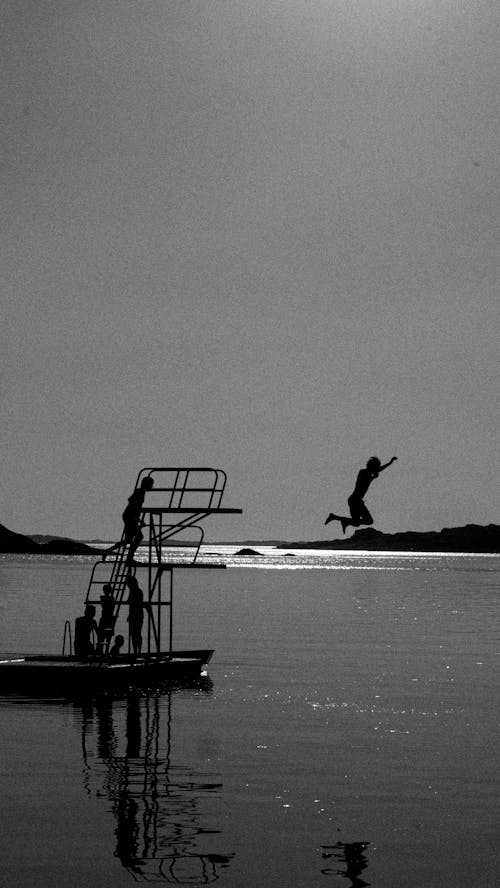 Free Grayscale Photo of Man Jumping on Water Stock Photo