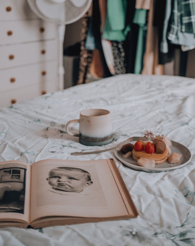 Child Face In Book On Bed