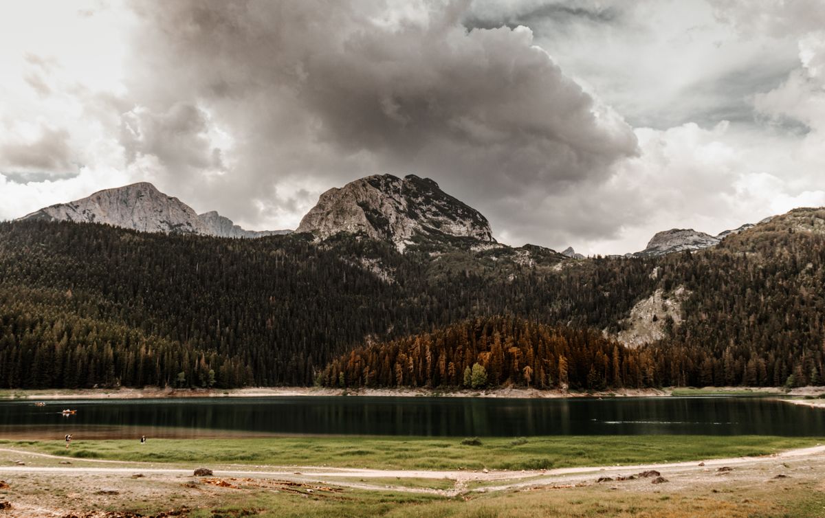 The Black Lake surrounded by pine forest under dramatic clouds, Durmitor