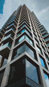 A striking skyscraper in The Hague with geometric glass windows captured from a low angle.