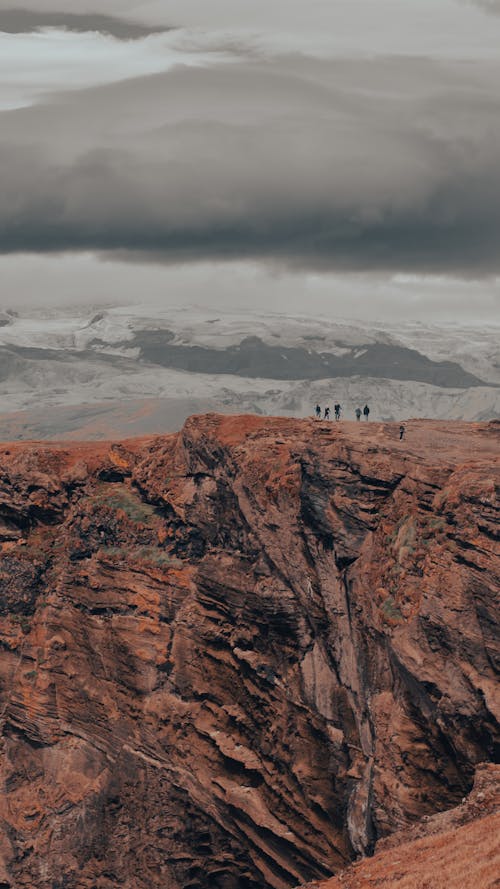 People Hiking on Rocks in Mountains