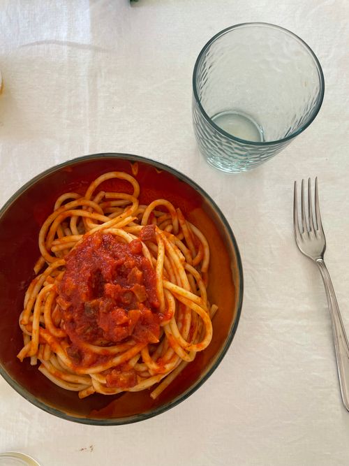 Free Top-down shot of spaghetti in tomato sauce on a white table with glass and fork. Stock Photo