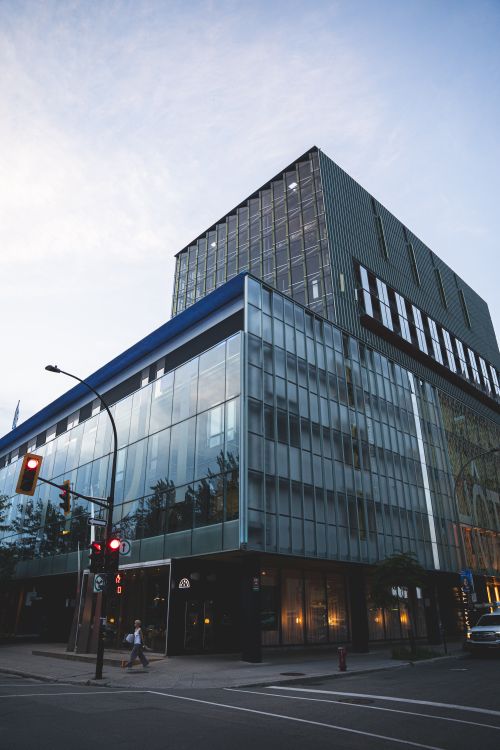 Free Contemporary glass architecture in Montréal, Canada, captured at dusk with city life in the background. Stock Photo