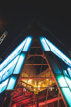 Captivating low angle shot of a modern building in Montréal, beautifully illuminated against the night sky.