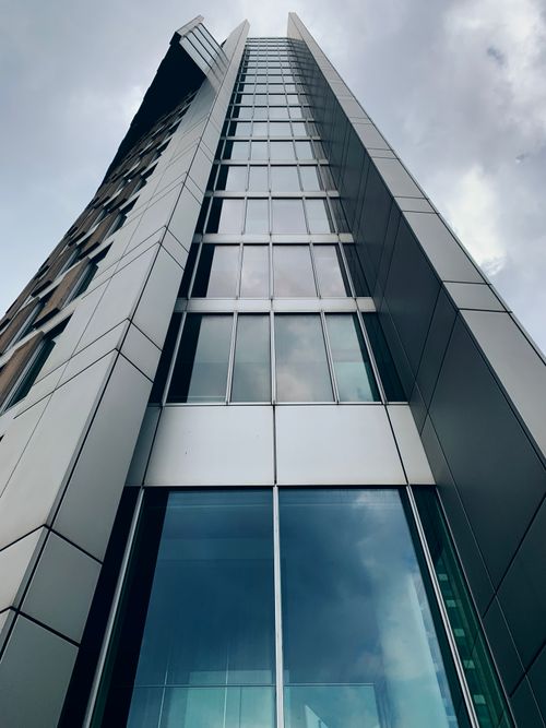 Free Low angle shot of a modern skyscraper facade in Den Haag, Netherlands under a gloomy sky. Stock Photo